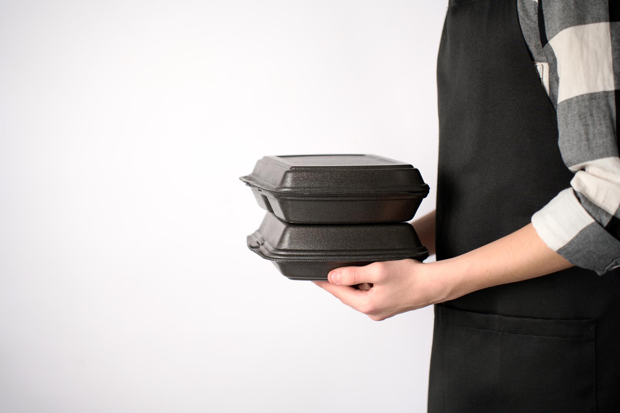 Friendly chef handing packaged meal